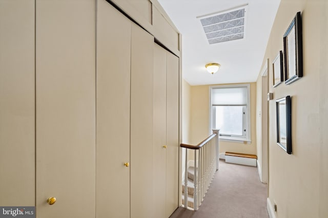 corridor featuring a baseboard heating unit and light carpet