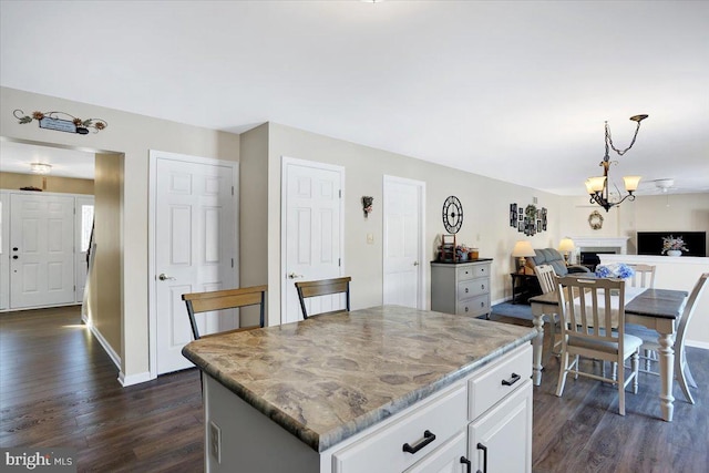 kitchen with white cabinetry, pendant lighting, dark wood-type flooring, and a kitchen island