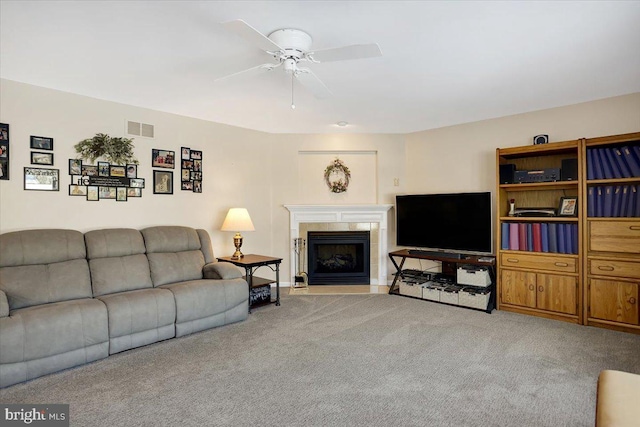 living room featuring light carpet, a fireplace, and ceiling fan