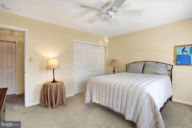 bedroom with ceiling fan, light carpet, and a closet