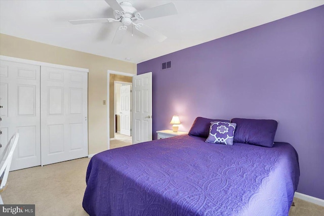 carpeted bedroom featuring ceiling fan and a closet