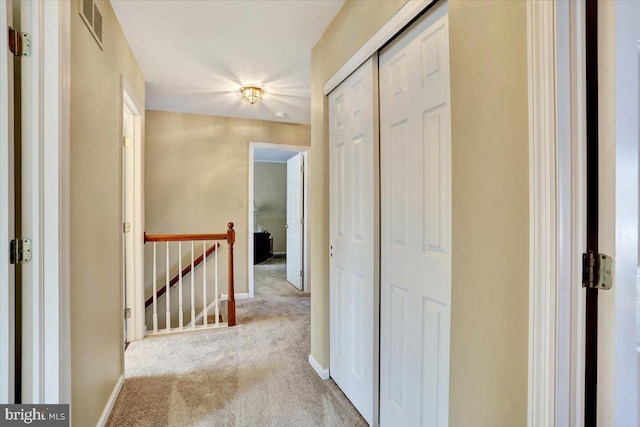 hall with light colored carpet