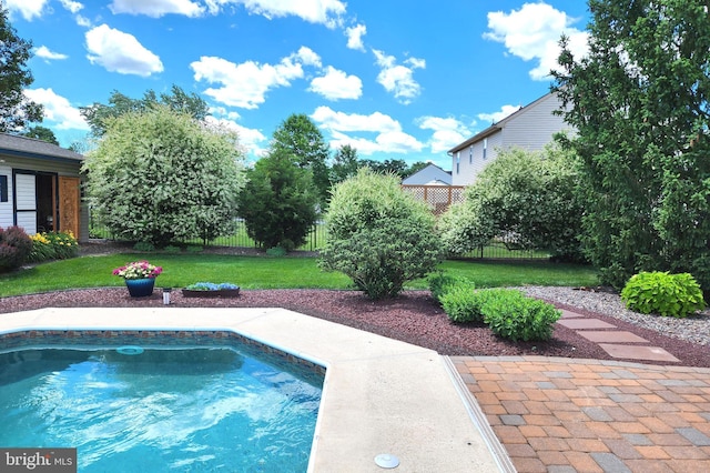 view of pool featuring a lawn