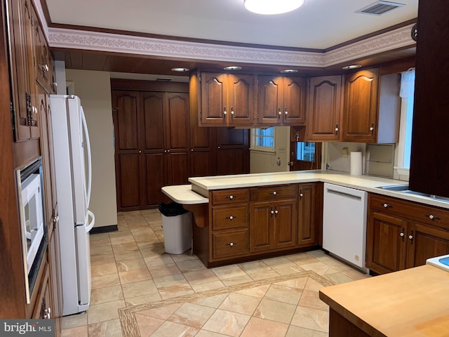 kitchen featuring kitchen peninsula and white appliances