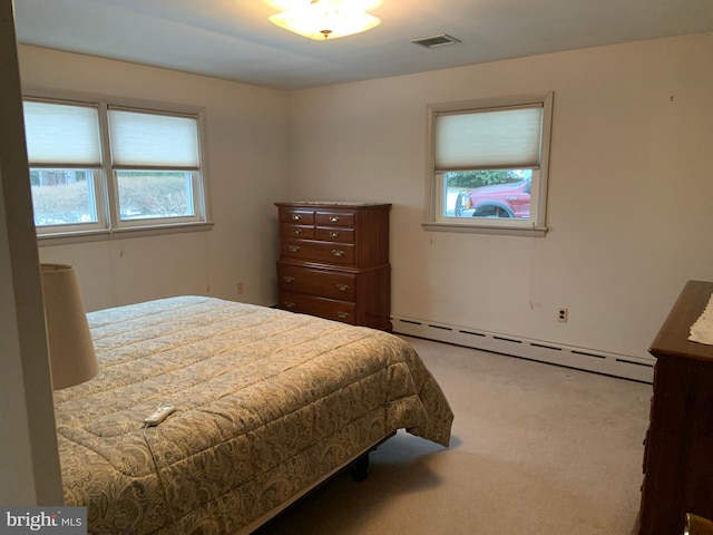 bedroom featuring baseboard heating and light colored carpet