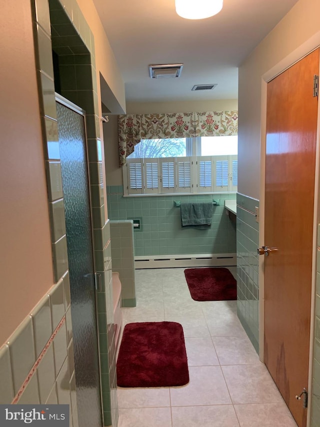 bathroom featuring walk in shower, tile walls, tile patterned floors, and a baseboard heating unit