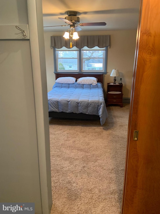 bedroom featuring ceiling fan, multiple windows, and carpet