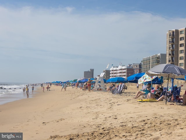 view of property's community featuring a water view and a beach view