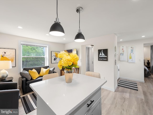 kitchen with pendant lighting, a center island, and light wood-type flooring