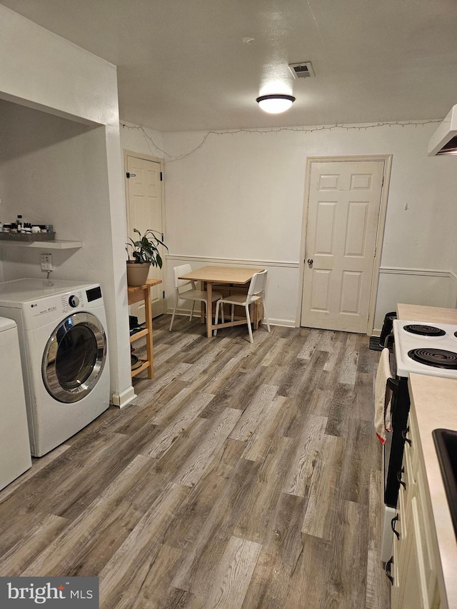 laundry room with wood-type flooring and independent washer and dryer