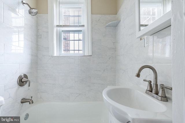 bathroom with tiled shower / bath combo and sink