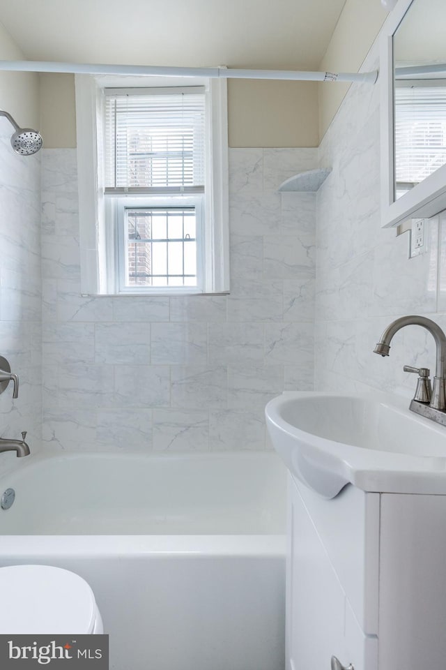 full bathroom with vanity, tiled shower / bath, and toilet