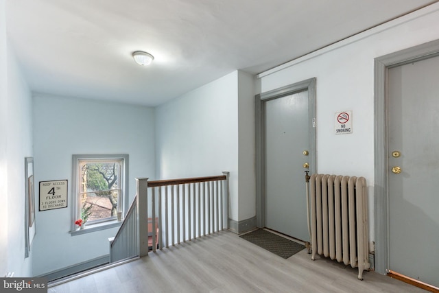 hallway featuring radiator heating unit and light wood-type flooring