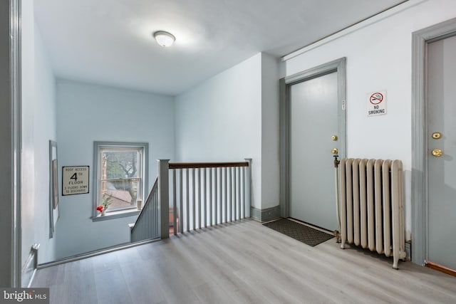 corridor featuring radiator and light hardwood / wood-style flooring