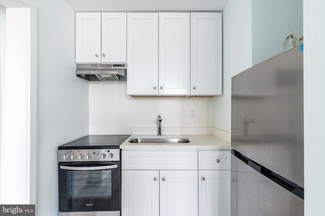 kitchen featuring stainless steel appliances, white cabinetry, and sink