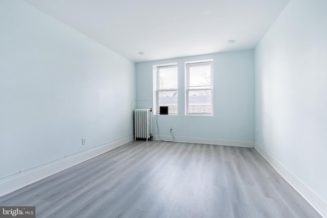 empty room featuring radiator and light hardwood / wood-style floors