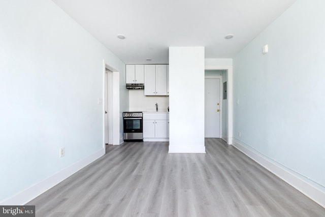 unfurnished living room featuring sink and light wood-type flooring