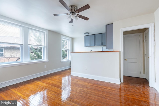 unfurnished living room with ceiling fan and dark hardwood / wood-style flooring