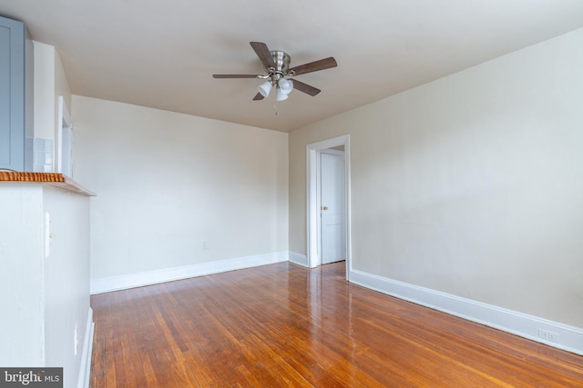 unfurnished room with ceiling fan and dark hardwood / wood-style flooring