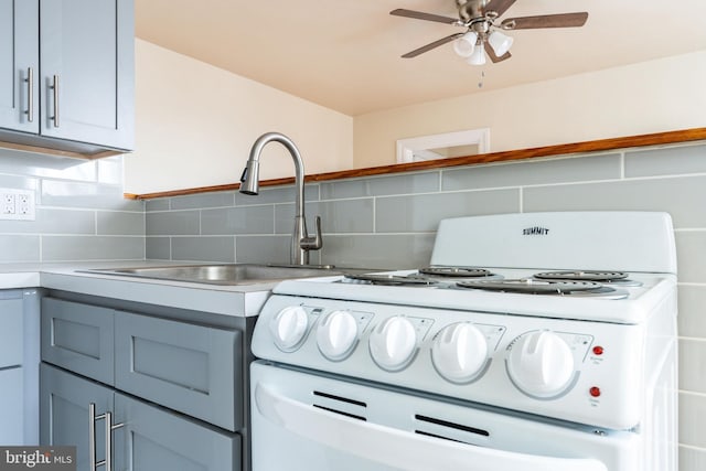 kitchen with white range, sink, decorative backsplash, and ceiling fan