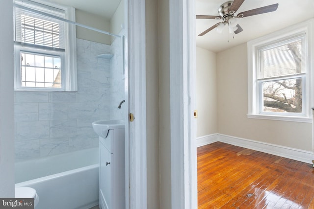 bathroom with vanity, hardwood / wood-style floors, tiled shower / bath, and ceiling fan