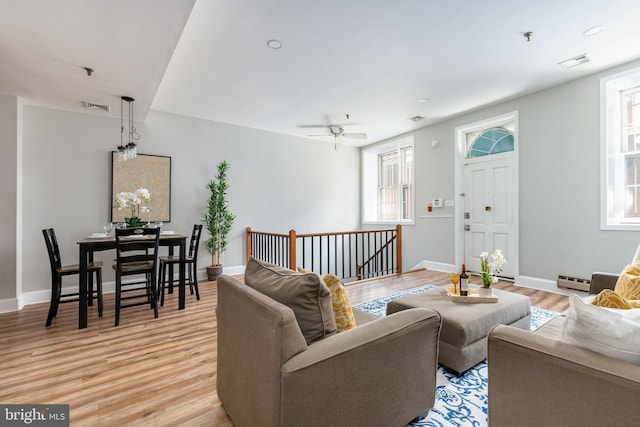 living room with baseboard heating and light wood-type flooring