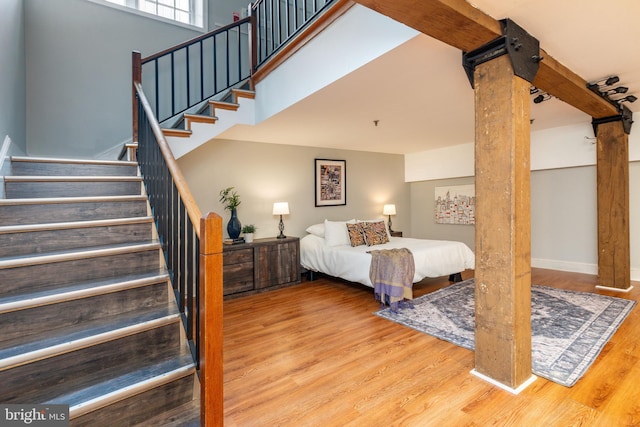 bedroom featuring a towering ceiling and light wood-type flooring