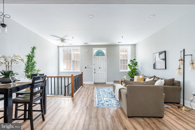 living room with light hardwood / wood-style flooring and ceiling fan