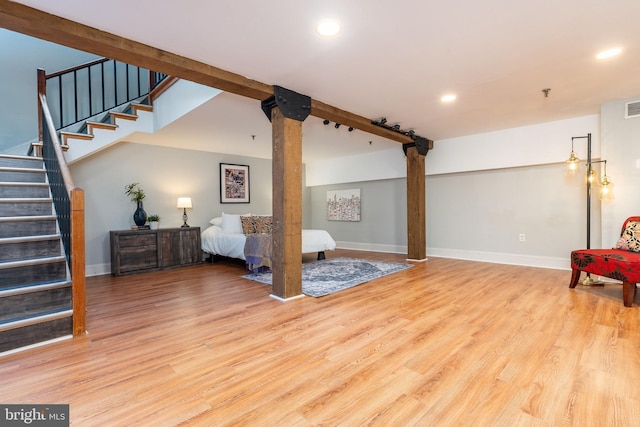 bedroom featuring decorative columns and light wood-type flooring