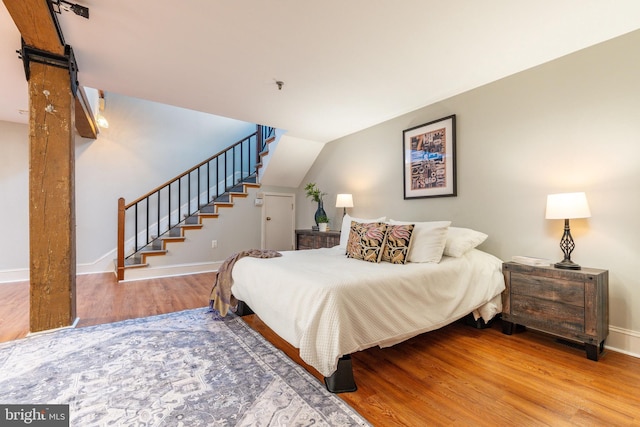 bedroom featuring hardwood / wood-style floors and lofted ceiling