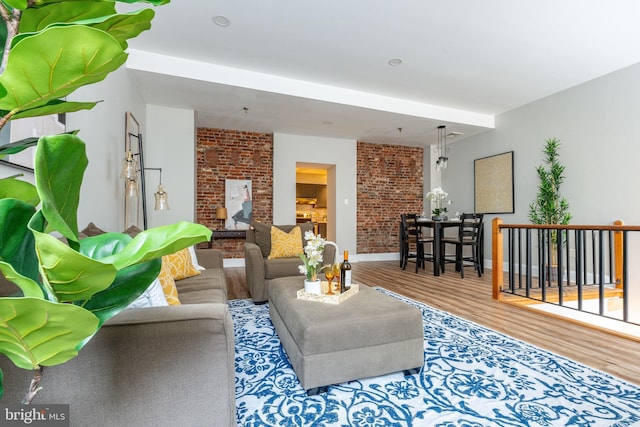 living room featuring hardwood / wood-style flooring and brick wall