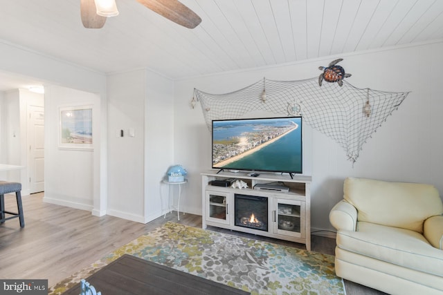 living room featuring crown molding, wood ceiling, wood-type flooring, and ceiling fan