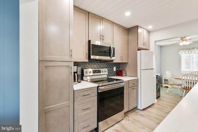 kitchen featuring ceiling fan, stainless steel appliances, decorative backsplash, and light wood-type flooring