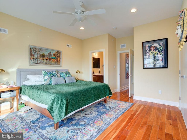 bedroom featuring ensuite bath, ceiling fan, and wood-type flooring