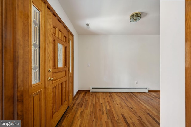 foyer with baseboard heating and hardwood / wood-style flooring