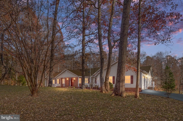 single story home with covered porch, a yard, and a garage