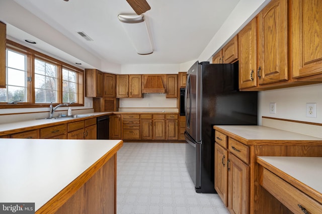 kitchen with custom range hood, black dishwasher, stainless steel fridge, and sink