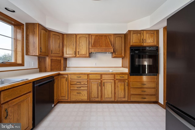 kitchen with sink, black appliances, and custom exhaust hood