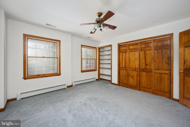 unfurnished bedroom with ceiling fan, baseboard heating, light colored carpet, and a closet