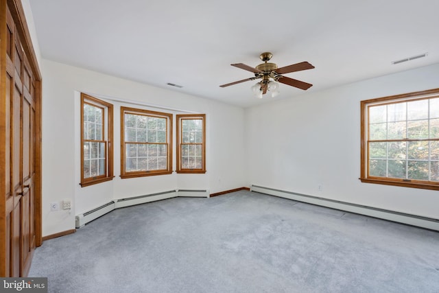 carpeted empty room featuring ceiling fan and a baseboard heating unit