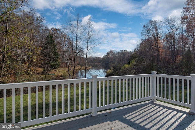 deck with a water view and a lawn