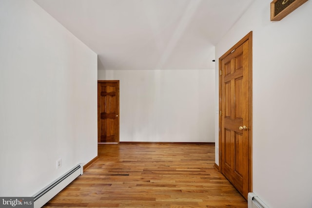 hallway featuring a baseboard heating unit and light hardwood / wood-style flooring