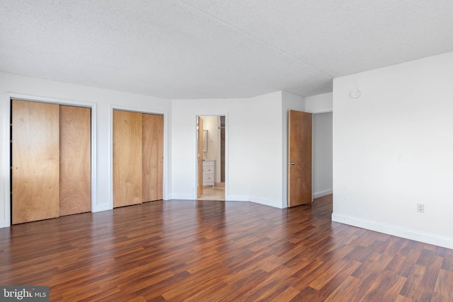 empty room with a textured ceiling and dark hardwood / wood-style flooring