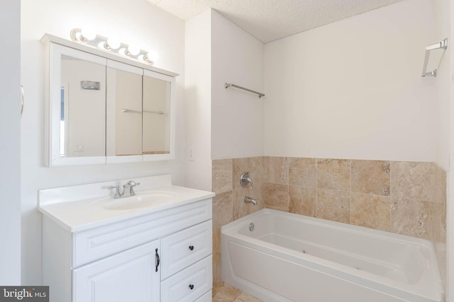 bathroom featuring vanity, a bathtub, and a textured ceiling