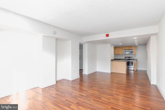 unfurnished living room featuring a textured ceiling and dark hardwood / wood-style floors