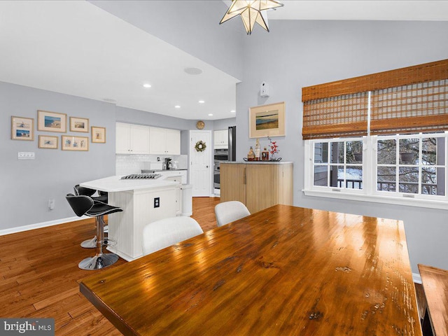 unfurnished dining area with vaulted ceiling and light hardwood / wood-style floors