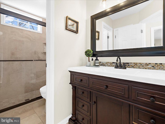 bathroom with a tile shower, backsplash, vanity, toilet, and tile patterned floors