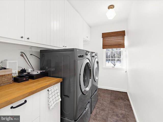 laundry area featuring separate washer and dryer and cabinets