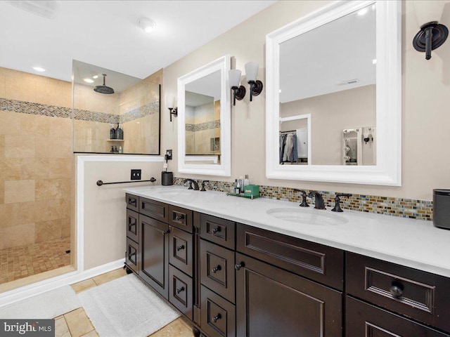 bathroom featuring tiled shower, vanity, tile patterned flooring, and backsplash