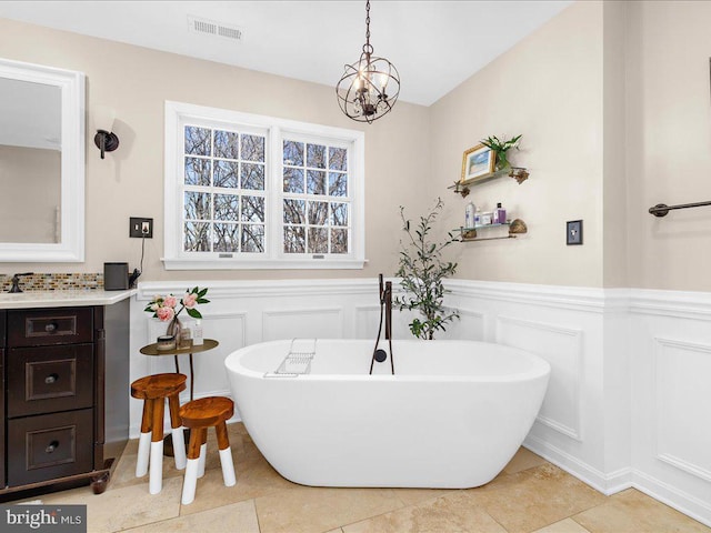 bathroom featuring tile patterned flooring, vanity, and a bath